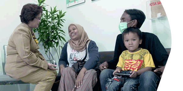 Image of health provider talking to a family in medical center or hospital