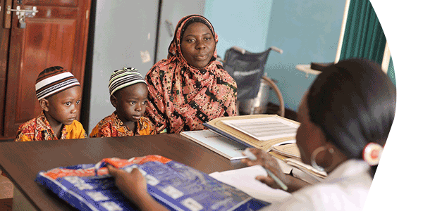 Nurse Pili Makota counsels Zamda Dadi, 23, with her two children Tofiki and Muksini, on how to use a long-lasting insecticide-treated mosquito net (ITN) at a dispensary in Naliendele, Tanzania