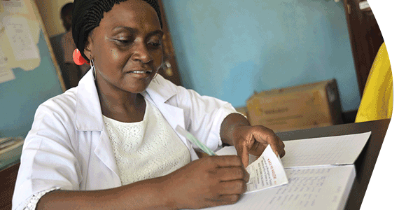 Nurse Pili Makota records client details prior to distributing a bed net at Naliendele Health Center in Tanzania.