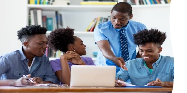 Four students working on a laptop