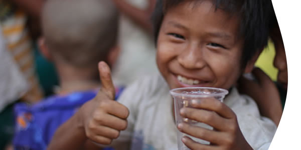 smiling boy with a glass of drinking water with thumbs up